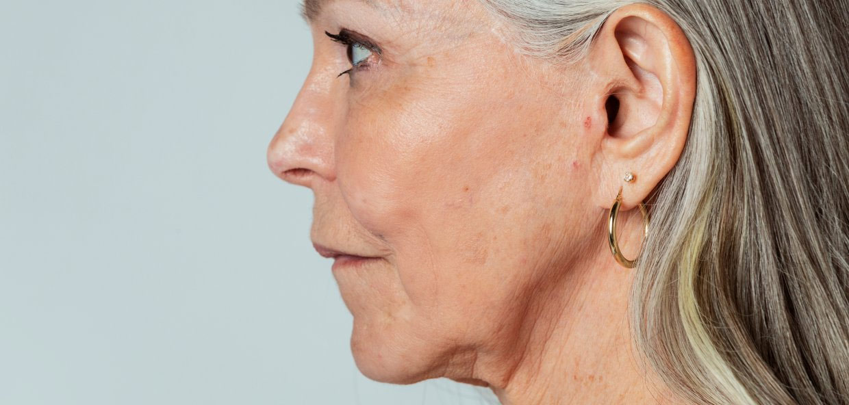 older woman looking to the side with earring