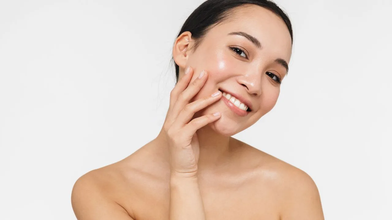 Asian woman posing naked isolated over white wall